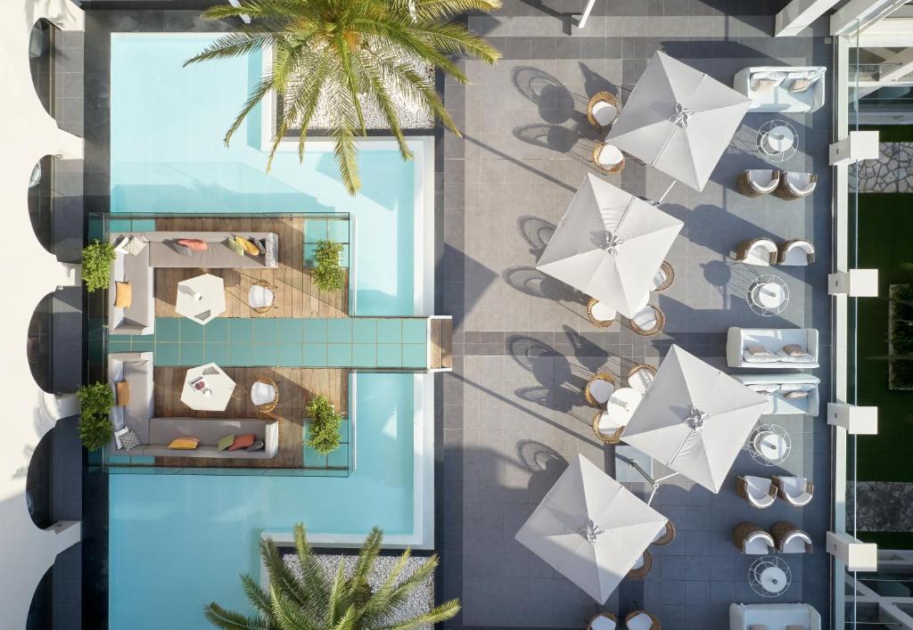 Mūsdienīgs baseins ar atpūtas zonām un saulessargiem, kas nodrošina relaksējošu atmosfēru. Ideāla vieta atpūtai un izklaidei ārā.