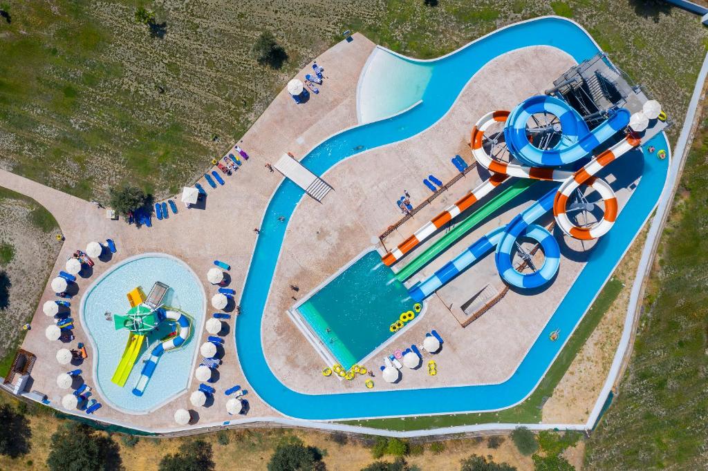Ūdens atrakciju parks ar dažādiem slidkalniņiem un peldbaseiniem, ideāli piemērots ģimenēm un bērniem. Skats no augšas uz izklaides un atpūtas zonām.
