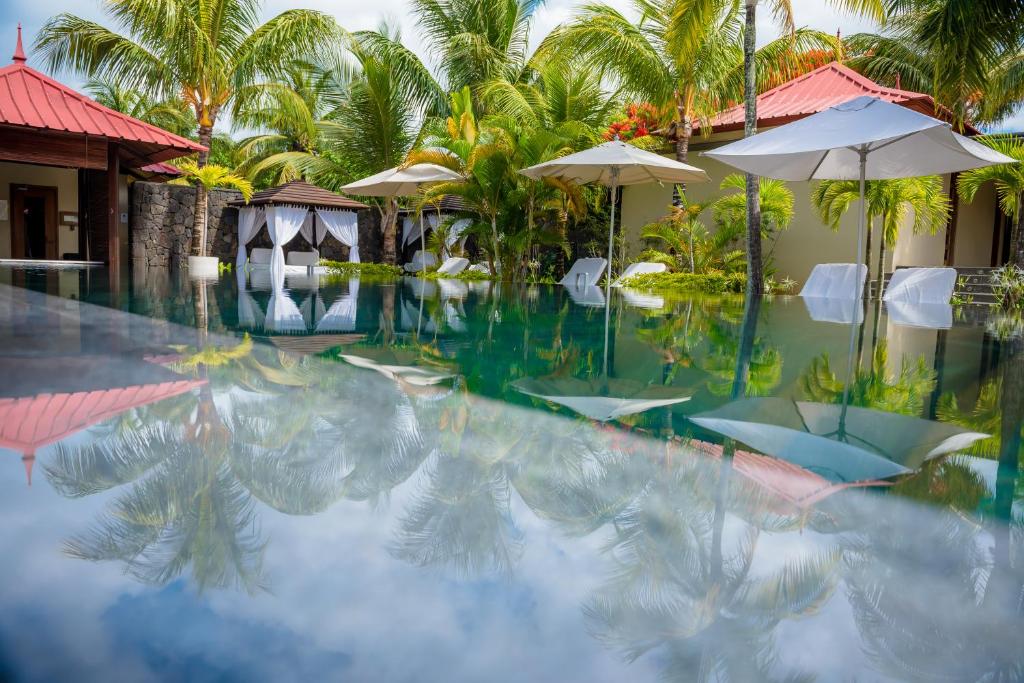 Viesnīcas Tamassa Bel Ombre baseins ar palmām un atpūtas zonām