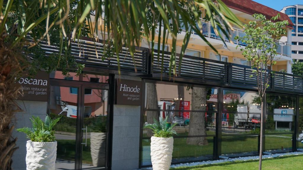 Restorāna "Hinode" un "Toscana" ieeja ar dārzu, modernā arhitektūrā un zaļumiem.