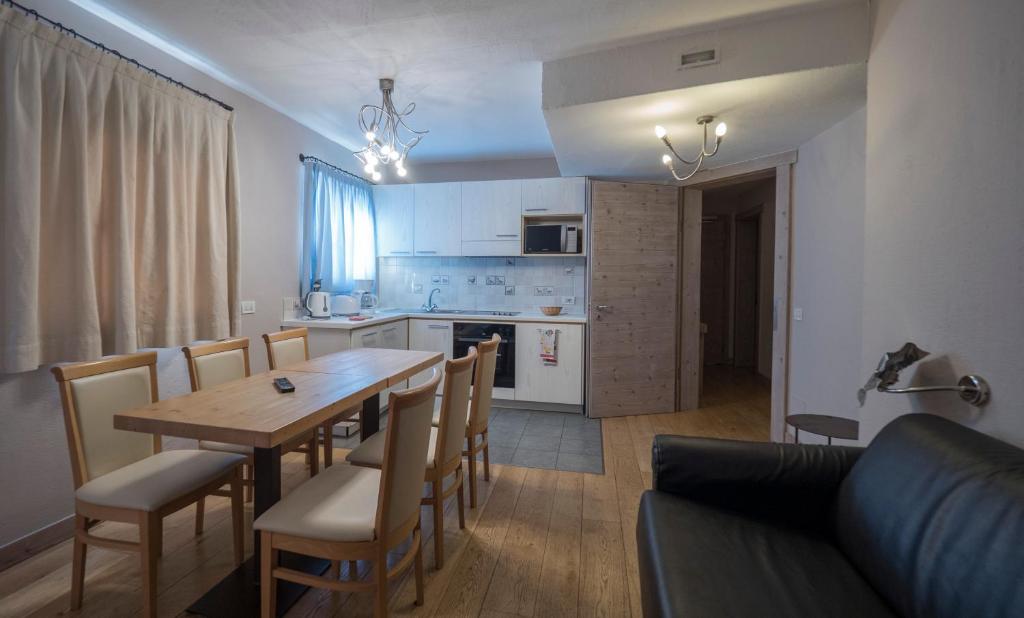 Grezna virtuve ar koka galdu un krēsliem, gaišām aizkariem un mūsdienīgu aprīkojumu. Telpa ir gaiša un plaša, radot mājīgu atmosfēru.