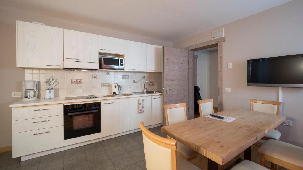 Moderns virtuves interjers ar koka galdu un baltām skapīša frontēm, papildināts ar tehnoloģijām, piemēram, mikroviļņu krāsni un televizoru. Gaisīgs un viesmīlīgs dizains.