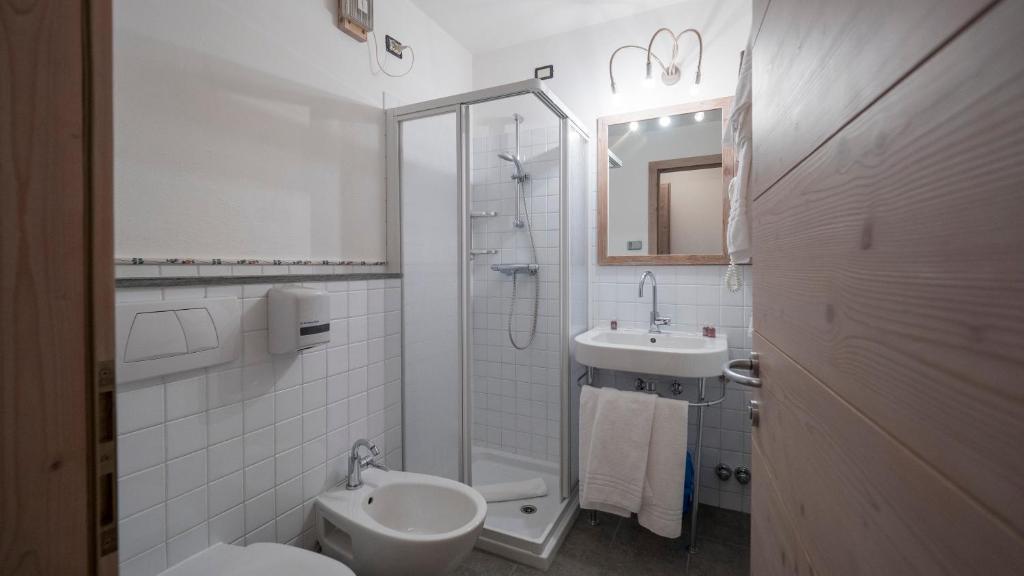 Mūsdienīga vannas istaba ar dušu, izlietni un tualeti, apdarē dominē baltā flīžu krāsa. Interjers ir gaišs un funkcionāls, ar koka elementiem.