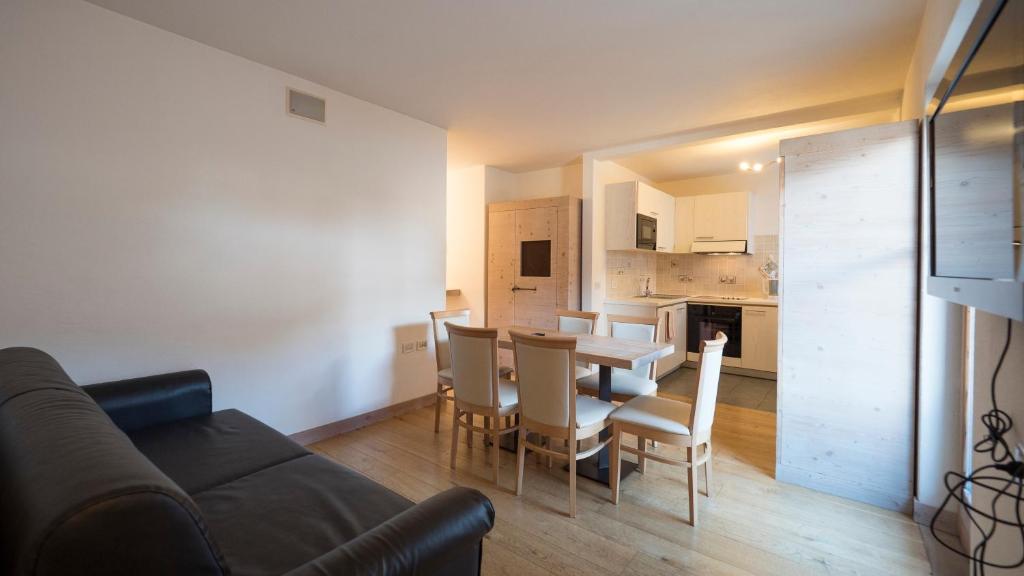 Mūsdienīga viesistaba ar virtuvi, kurā ir koka grīda, ēdamgaldu un ērtu dīvānu. Telpa ir gaiša un ērta, ideāli piemērota atpūtai.