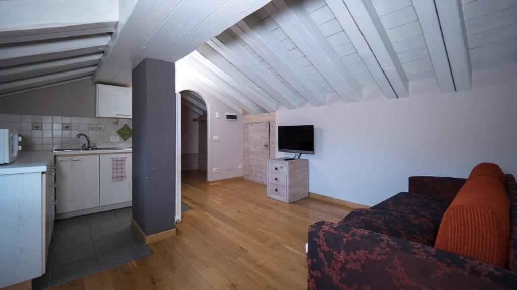 Mājīgs mansards ar modernu virtuvi, viesistabu un televizoru. Baltās koka sijas piešķir telpai gaisīgu atmosfēru.