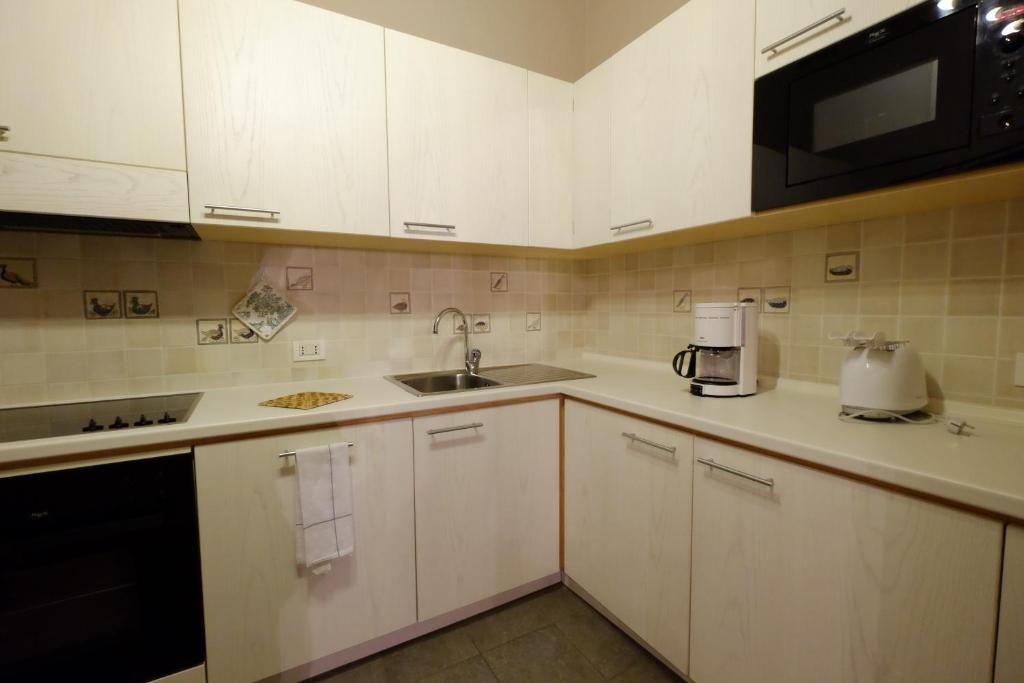 Mūsdienīga virtuve ar gaišām mēbelēm, iebūvētu plīti un mikroviļņu krāsni, kā arī kafijas automātu un tējkannu. Eleganta un funkcionāla dizaina interjers.