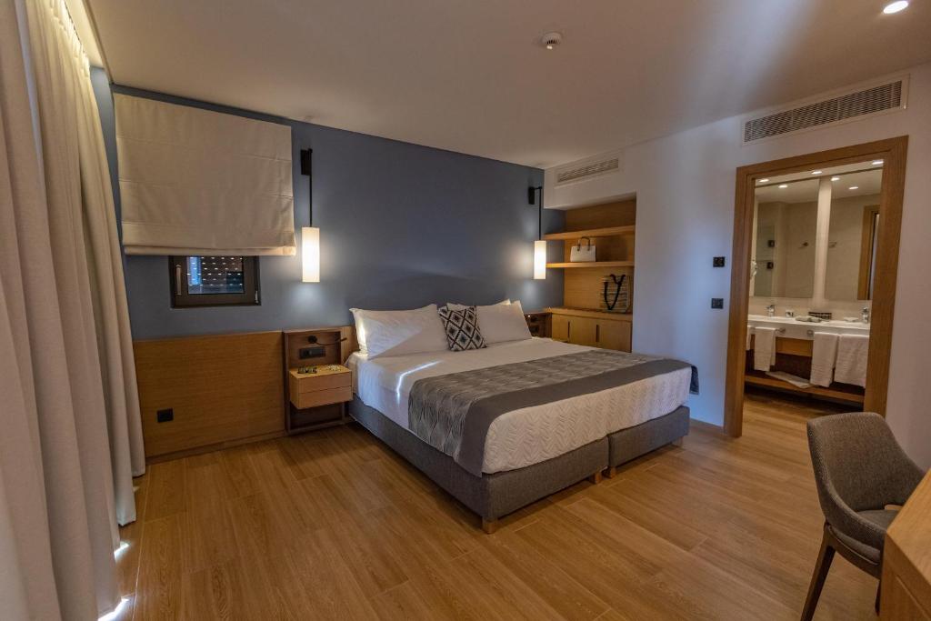 Mūsdienīga viesnīcas numura iekārtojums ar ērtu gultu, koka grīdu un minimālistisku dizainu. Numurā ir arī piekļuve vannas istabai un rakstāmgalds.