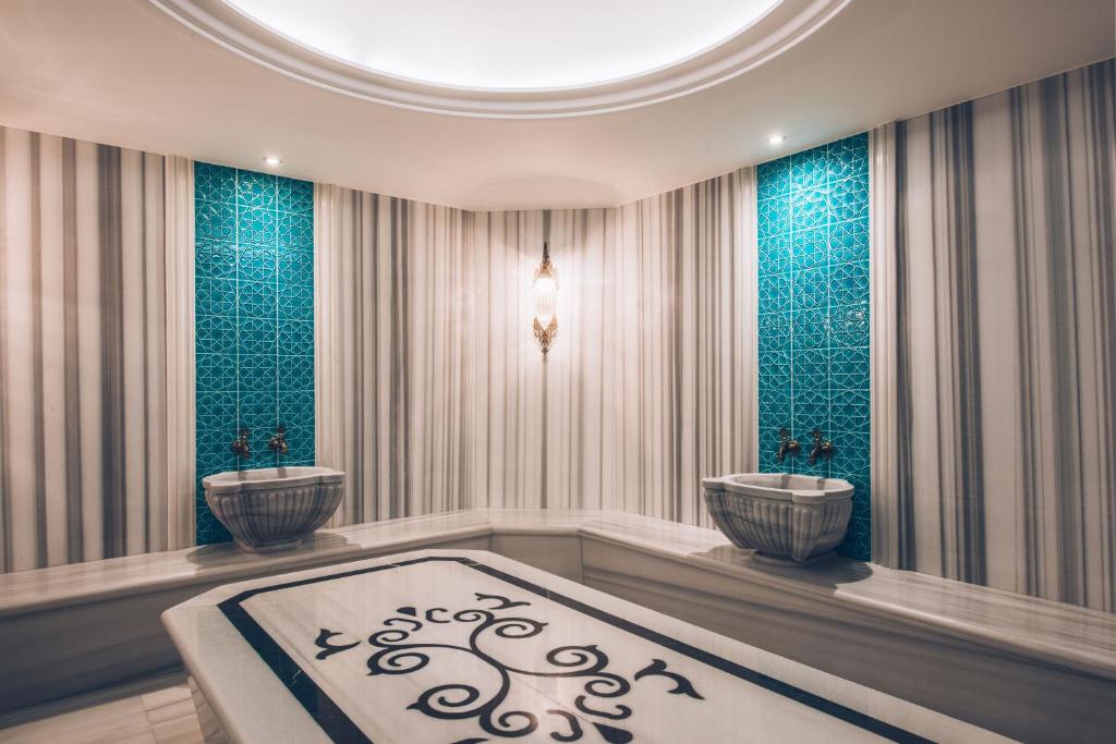 Mūsdienīgs spa telpas interjers ar elegantiem akmens izstrādājumiem, zilo flīžu akcentiem un relaksējošu atmosfēru.