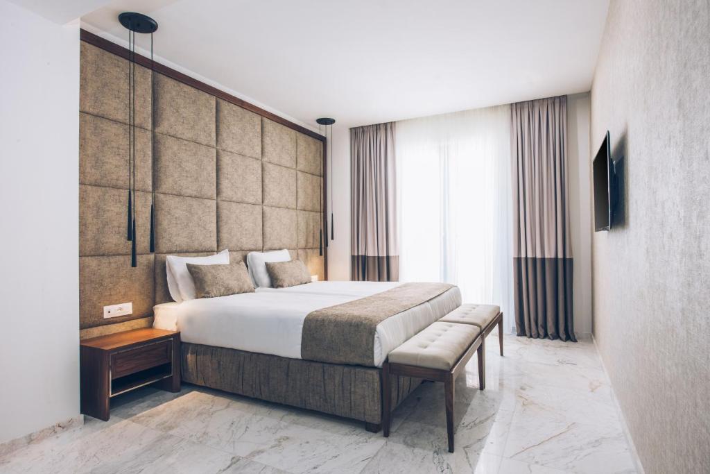 Mūsdienīga guļamistaba ar plašu gultu, elegantu apdari un lieliem logiem, kas nodrošina dabisko apgaismojumu. Interjers ir vienkāršs, ar neitrālām krāsām un minimālistisku stilu.