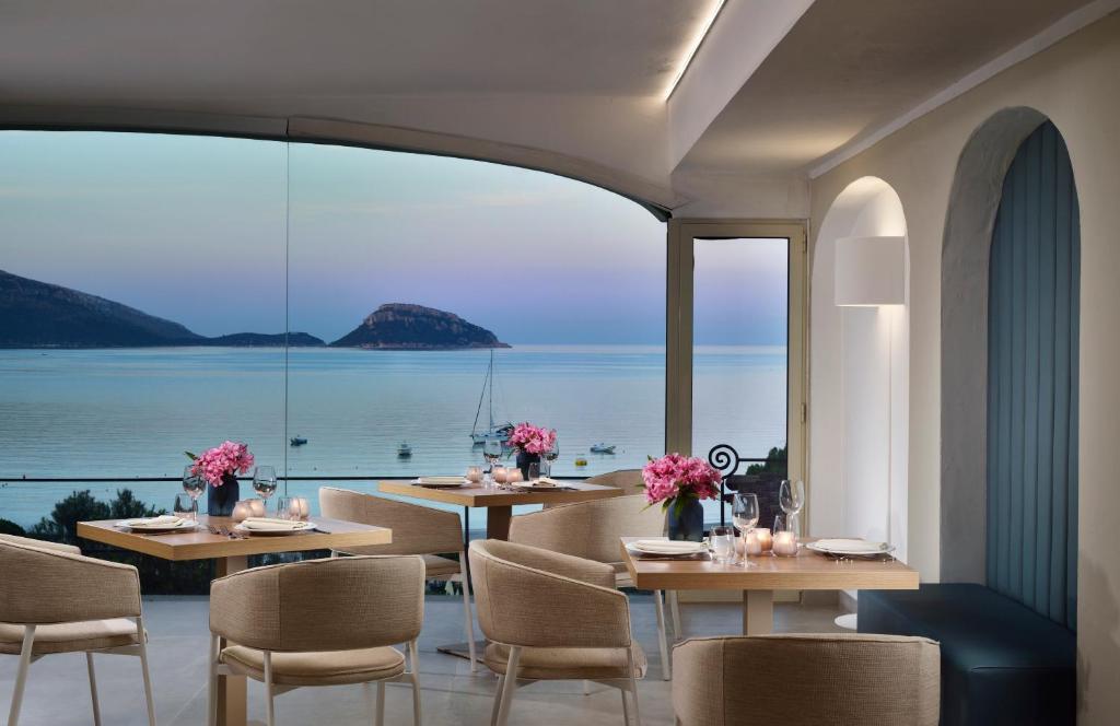 Moderns restorāns ar elegantām galdiem un rozā ziediem, kas piedāvā skatu uz mierīgu jūru un kalniem. Interjers ir gaišs un stilīgs, radot relaksējošu atmosfēru.