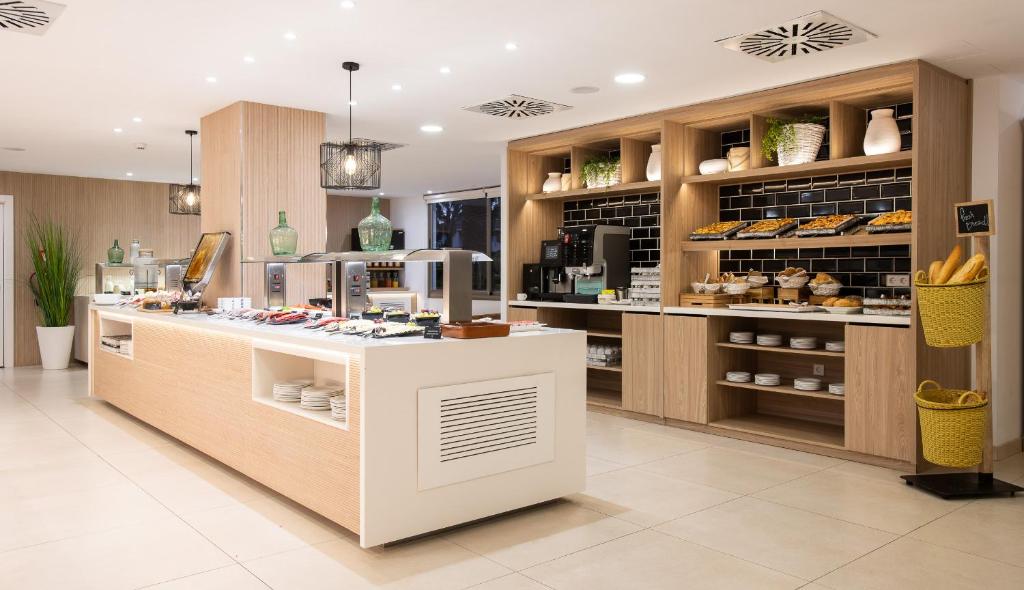 Mūsdienīgs bufetes stils ar koka elementiem un plašu ēdienu izvēli, ieskaitot konditorejas izstrādājumus un dzērienus. Gaismas un zaļumi piešķir telpai patīkamu atmosfēru.