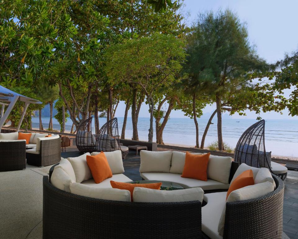 Eleganta āra atpūtas zona ar komfortablām mēbelēm un skatu uz pludmali, ieskauta kokiem un zaļumiem. Ideāla vieta relaksācijai un atpūtai pie jūras.