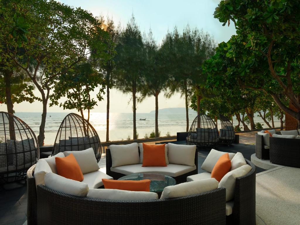 Mūsdienīga atpūtas zona pie jūras ar ērtiem dīvāniem un spilveniem, kas ieskauta zaļiem kokiem un skaistu saulrietu. Ideāla vieta relaksācijai un atpūtai.