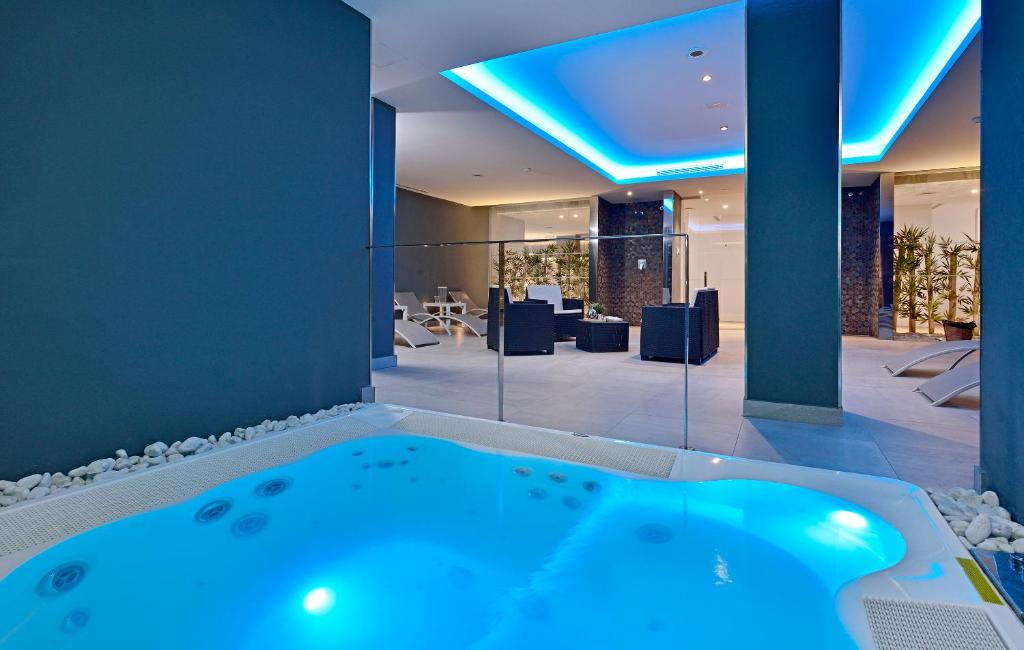 Mūsdienīgs spa ar burbuļvannu un relaksējošu apgaismojumu, kas rada mierīgu atmosfēru. Telpā ir moderni mēbeļu komplekti un augu dekorācijas, kas veicina atpūtu.