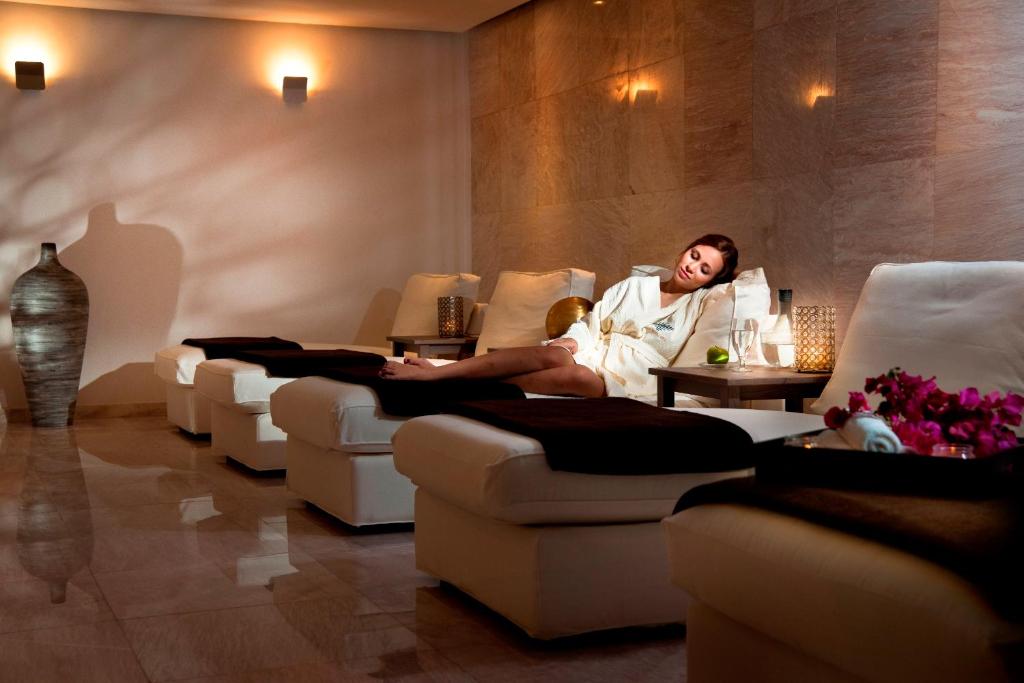 Relaksējoša spa vide ar komfortablām atpūtas vietām un apgaismojumu, kur sieviete baudīja mierīgu brīdi. Ideāla atmosfēra, lai atgūtu spēkus un relaksētos.