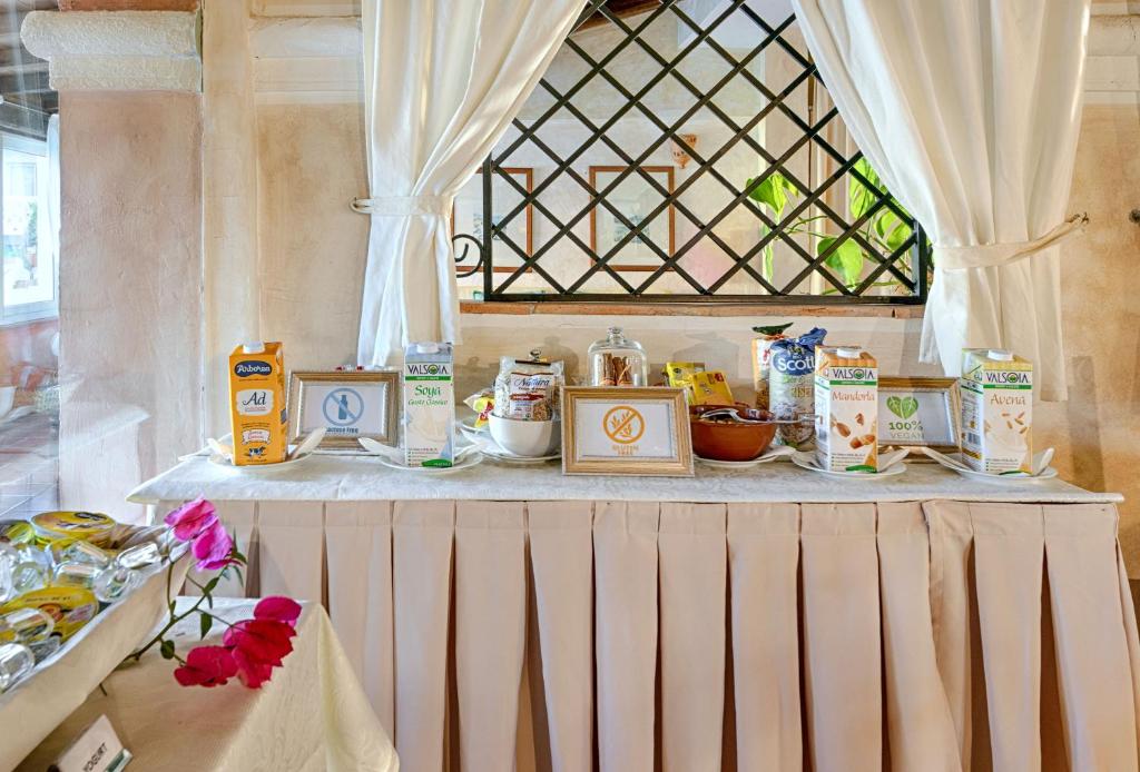 Uz galda ir izvietoti dažādi dzērieni un uzkodas, ieskaitot augu izcelsmes pienu un riekstu produktus, apvienojot veselīgu uzturu un viesmīlību. Galda dekorēšanai izmantoti ziedi un eleganta balta galdauta.