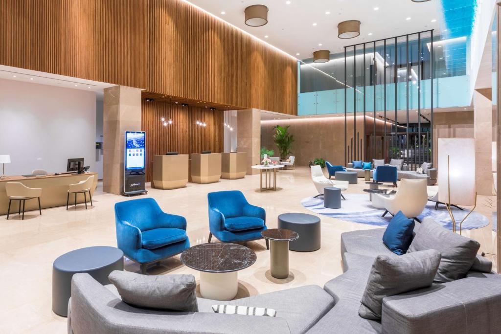 Mūsdienīga viesnīcas recepcija ar elegantiem mēbeļu elementiem un plašu atpūtas zonu, kas piedāvā komfortu un stilīgu atmosfēru.