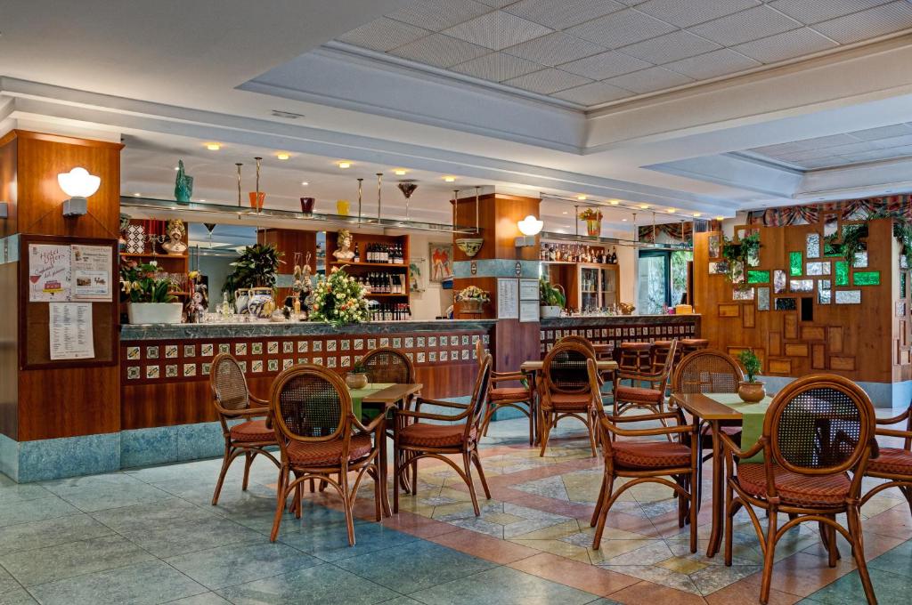 Mūsdienīgs restorāna interjers ar koka bāru un krāsainām flīzēm, kas rada patīkamu atmosfēru. Pusstundas galdi ar ratu krēsliem ir ērti izvietoti, aicinot viesus baudīt maltītes.