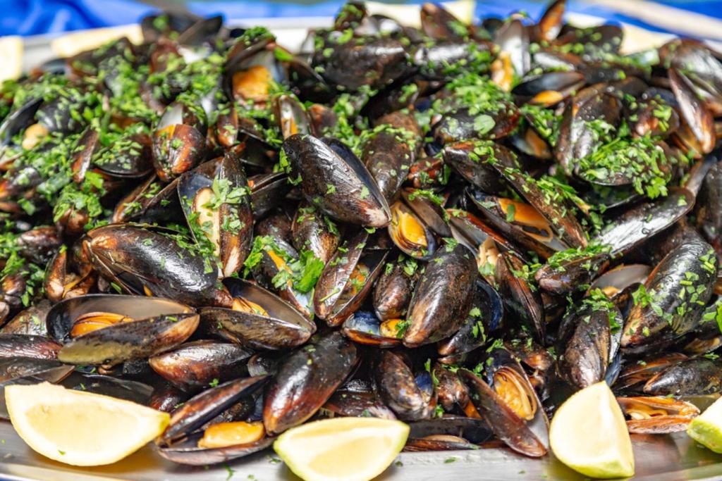 Mizas ar zaļumiem un citrona šķēlēm, kas sakrautas uz plata šķīvja, veido gardu jūras velšu ēdienu.