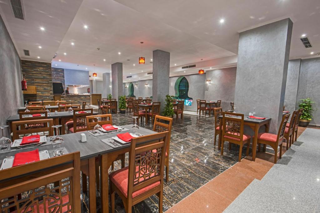 Mūsdienīgs restorāns ar elegantām koka mēbelēm, sarkaniem galdautiem un stilīgu interjeru. Gaismas elementi un augi piešķir siltumu un komfortu.