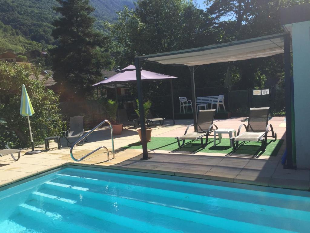 Peldbaseins ar saules krēsliem un lapeni, apkārt zaļiem kokiem un kalniem, radot relaksējošu atpūtas vidi. Ideāla vieta atpūtai un vasaras aktivitātēm.