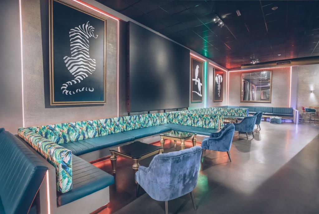 Mūsdienīgs interjers ar krāsainu dīvānu un mākslas darbiem uz sienām, radot stilīgu atmosfēru. Ideāla vieta relaksācijai un socializācijai.