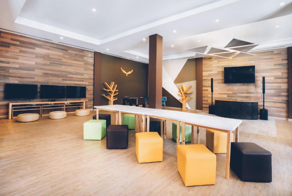 Mūsdienīga un stilīga atpūtas telpa ar koka sienām, ērtām sēdvietām un ekrāniem, kas paredzēta relaksācijai un socializācijai. Telpa ir aprīkota ar modernām gaismas ierīcēm un dekoratīviem elementiem.