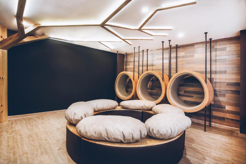 Mūsdienīga atpūtas telpa ar koka elementiem un apaļām, mīkstām sēdvietām. Telpa ir apgaismota ar modernām lampām, radot relaksējošu atmosfēru.