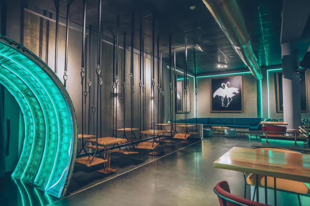 Mūsdienīgs interjers ar stilīgu apgaismojumu un šūpuļkrēsliem, kas rada relaksējošu atmosfēru. Telpā ir eleganti galdi un mākslinieciskas gleznas, kas papildina kopējo estētiku.