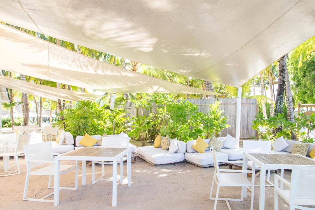 Pludmales atpūtas zona ar ērtām dīvānu vietām un galdiem, apstādīta ar zaļām augiem un pasargāta ar auduma nojumi. Ideāla vieta relaksācijai pie jūras.