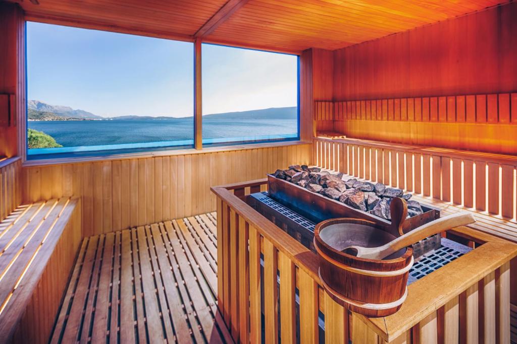 Mūsdienīga sauna ar koka apdari un skatu uz ezeru, nodrošinot relaksējošu atmosfēru un dabas skaistumu. Ideāla vieta atpūtai un labsajūtai.