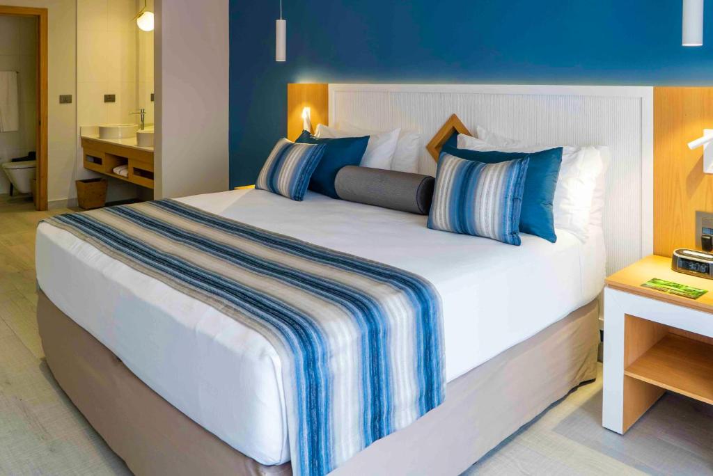 Mūsdienīgs viesnīcas numurs ar plašu gultu, dekorētu ar strīpainām gultas pārklājām un spilveniem, kā arī ar harmonisku zilu sienu un koka mēbelēm. Numurā ir pieejams vannas istaba un naktsgaldiņš ar lampu.