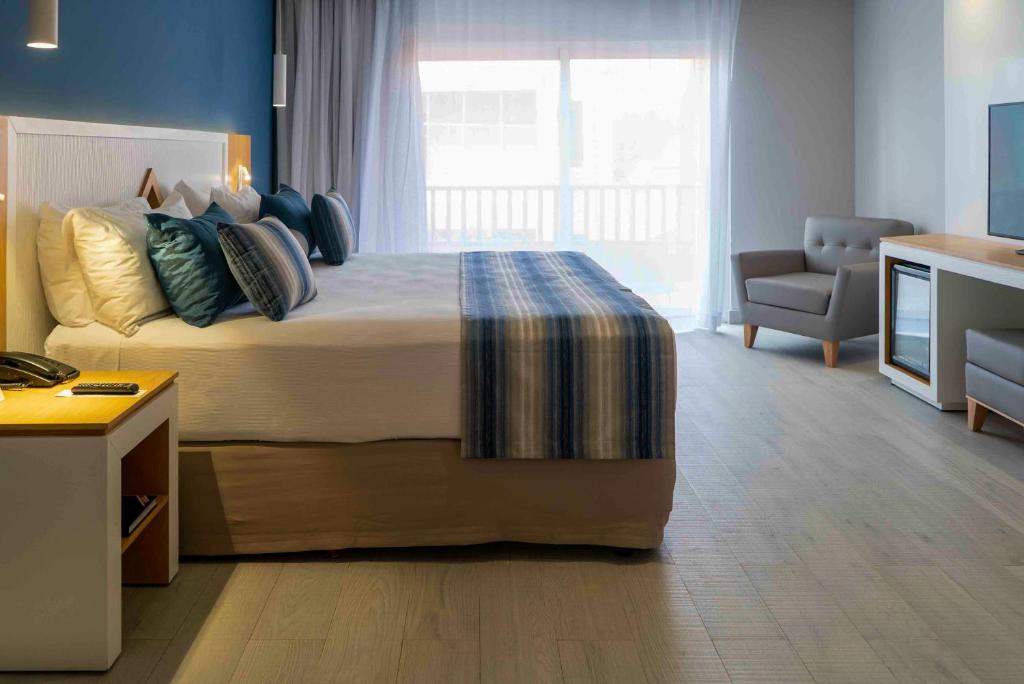 Mūsdienīgs viesnīcas numurs ar ērtu gultu un plašu logu, kas ļauj ieplūst dabiskajai gaismai. Interjerā dominē mierīgas krāsas, kā arī ir pieejams sēžamais stūris un televizors.