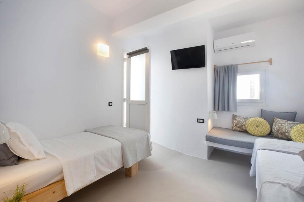 Gaiša un moderna viesistaba ar divām gultām, televizoru un ērtu sēdvietu. Telpa ir minimālistiski izdekorēta ar baltām sienām un dabīgiem koka akcentiem.