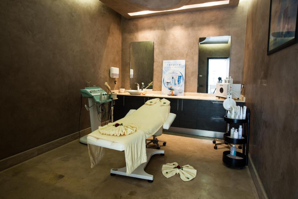 Mūsdienīgs spa telpa ar masāžas galdu, kosmētikas līdzekļiem un spoguli. Telpa ir iekārtota ar neitrālām krāsām, radot relaksējošu atmosfēru.