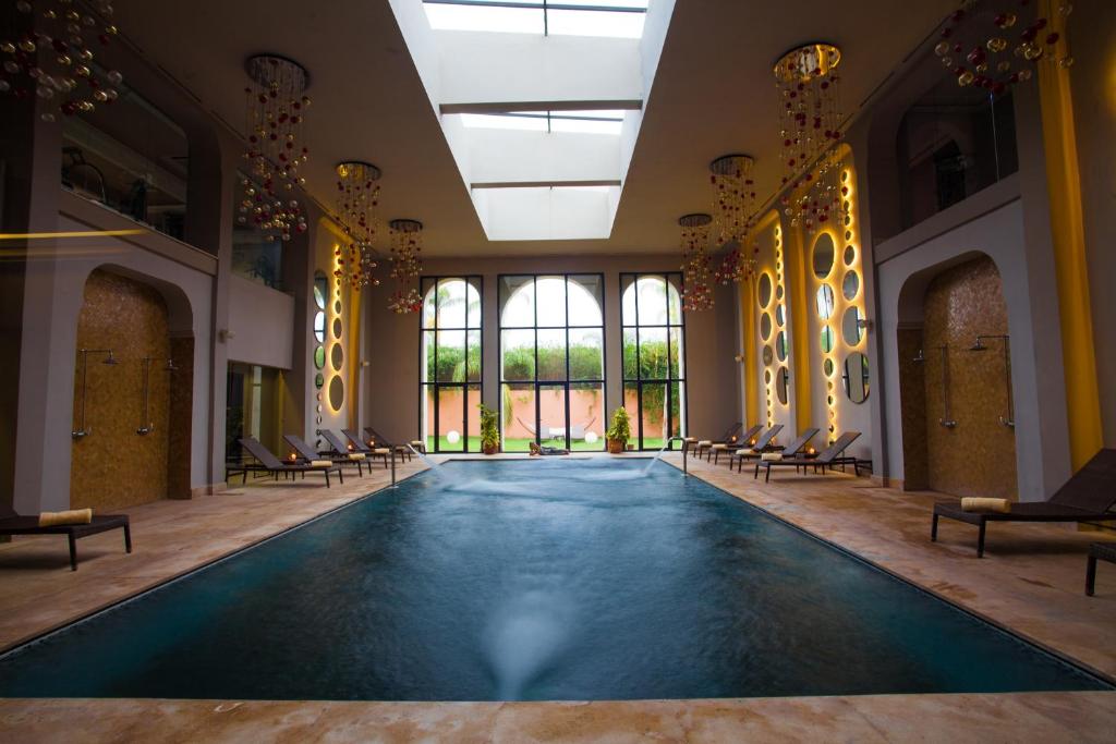 Luksusa spa telpa ar peldbaseinu un modernu interjeru, kurā ir daudz gaismas un relaksējoša atmosfēra. Sienas rotā dekoratīvi elementi, kas piešķir telpai eleganci.