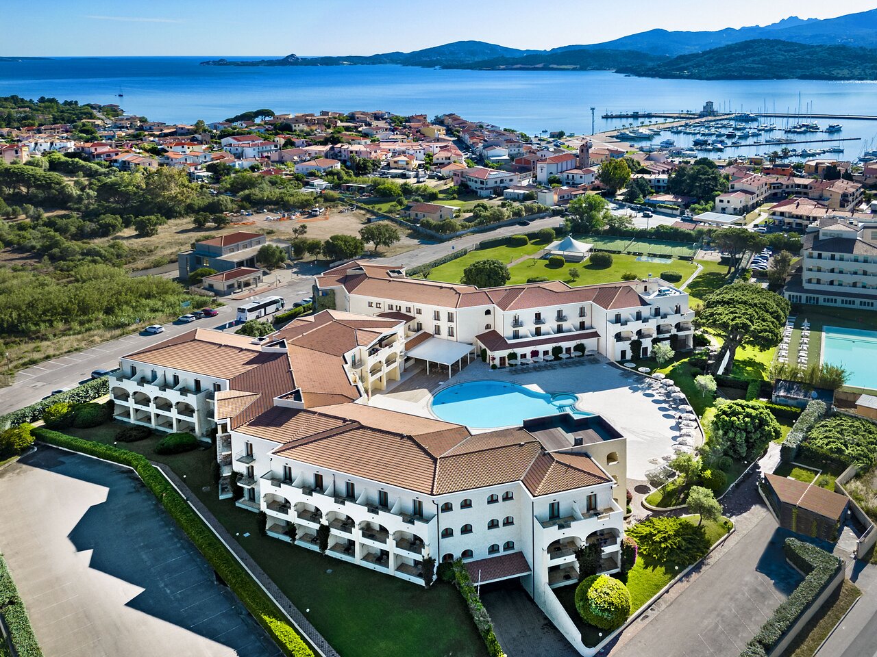 Viesnīca ar baseinu un piekrastes skatu, apkārt esošās mājas un ostas ainava. Ideāla vieta atpūtai un brīvdienām pie jūras. panoramic view with beach and pools