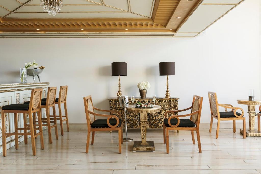 Eleganta interjera ar koka mēbelēm, stilīgu lampu un dekoratīviem elementiem. Telpa ir gaiša un moderna, radot viesmīlīgu atmosfēru.