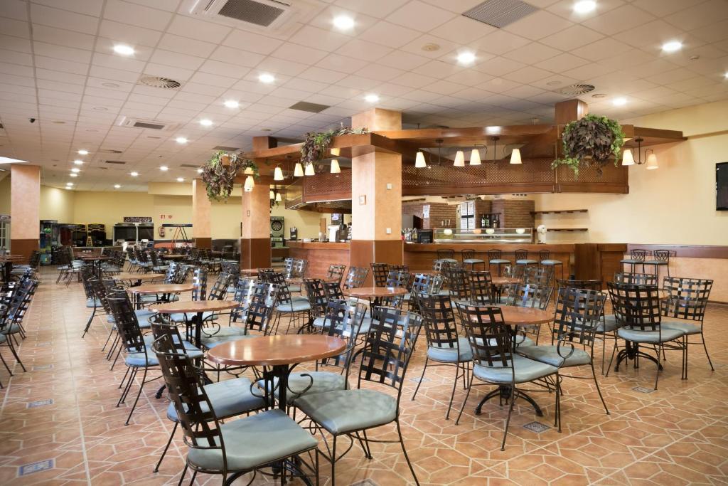 Plaša kafejnīca ar melnām metāla krēslām un apaļām galdiem, kas gaida apmeklētājus. Interjerā ir siltas krāsas un dabiski elementi, radot viesmīlīgu atmosfēru.