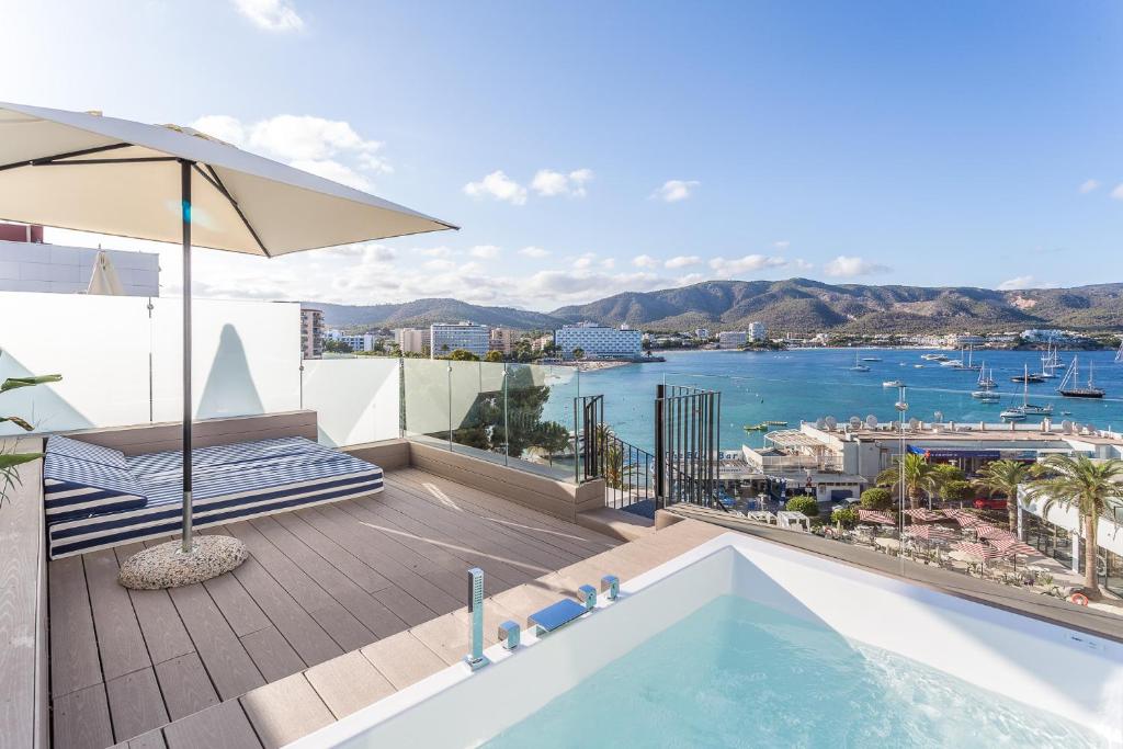 Balkons ar burvīgu skatu uz jūru, kur atrodas sauļošanās krēsls un ūdens baseins, ar kalnu ainavu fona.