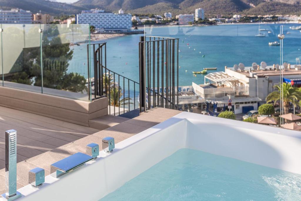 Pārliecinošs skats no terases ar jacuzzi, kas piedāvā gleznainu skatu uz jūru un pilsētas ainavu. Ideāla vieta atpūtai un relaksācijai.