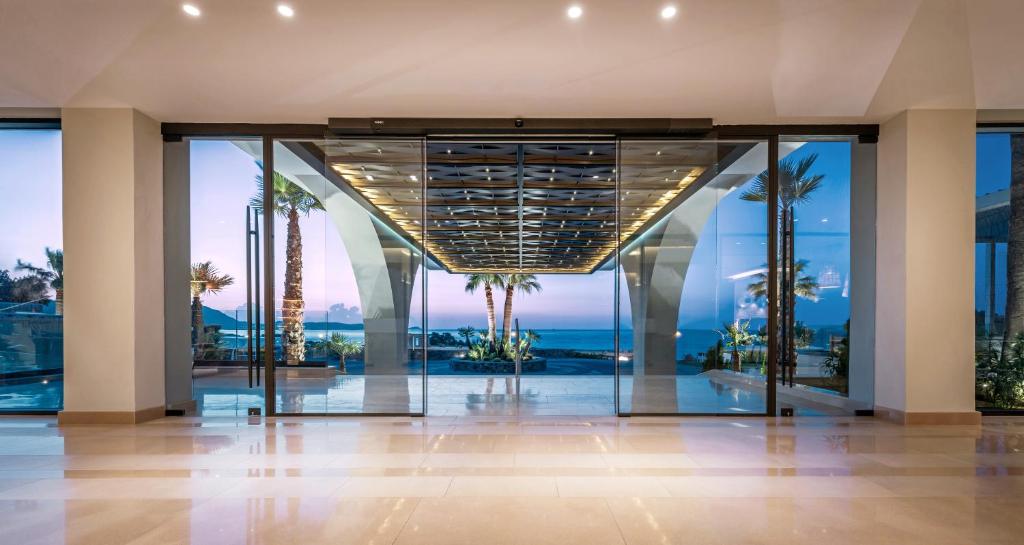 Mūsdienīga villa ar plašu stikla fasādi, kas nodrošina skatu uz jūru un palmu dārzu. Telpa ir apgaismota ar siltu gaismu un kombinēta ar elegantu interjeru.