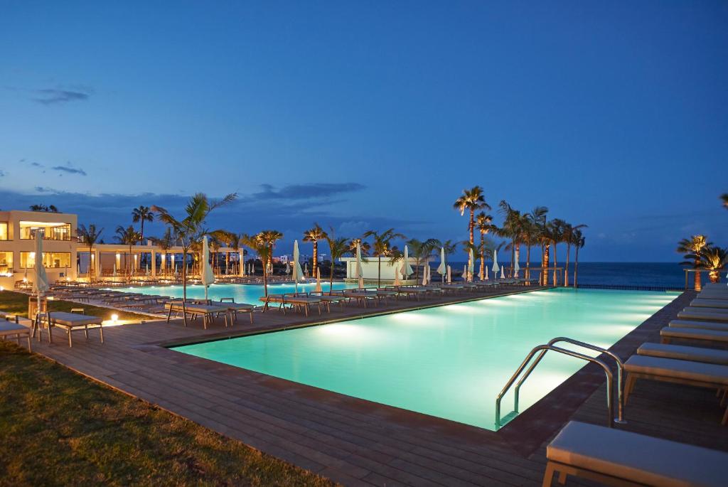 Sunrise Jade viesnīcas baseins piekrastē vakara laikā.