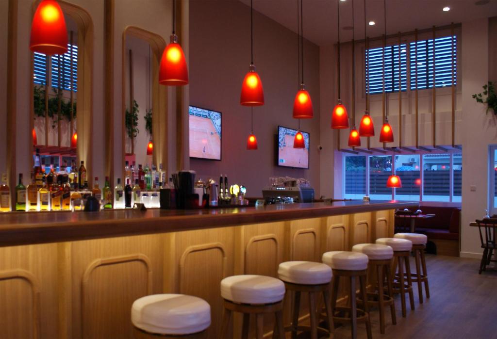 Sunrise Jade bārs ar sarkaniem lukturiem un koka mēbelēm