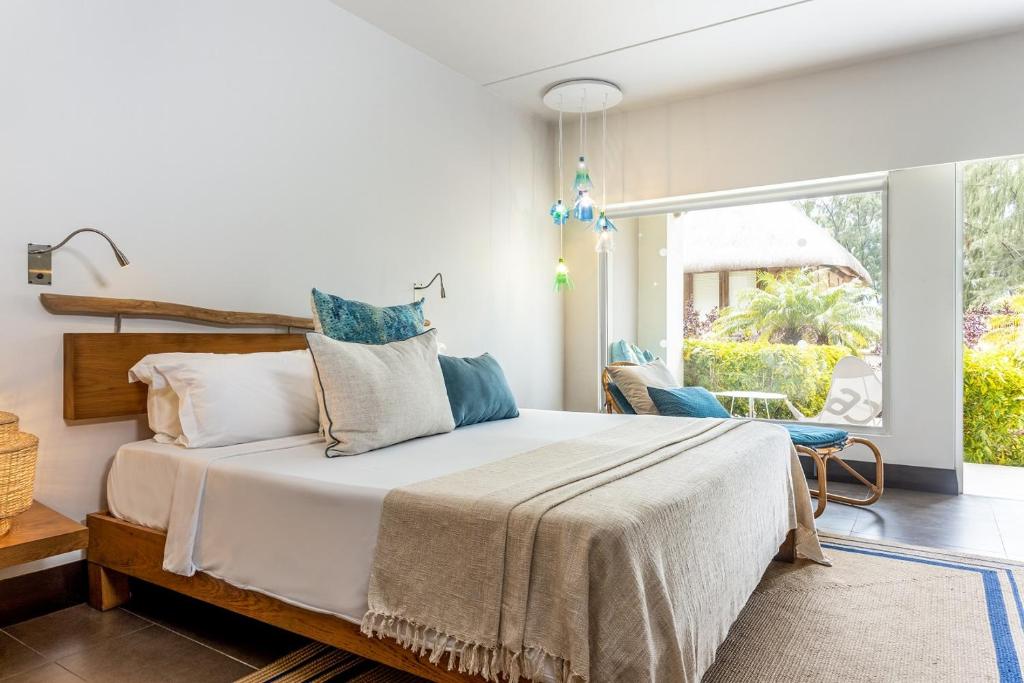 Mūsdienīgs guļamistabas interjers ar ērtu gultu un dabīgu koka akcentiem, kas ļauj baudīt dabu caur plašiem logiem. Svaiga un relaksējoša atmosfēra ar mīkstām tekstūrām un krāsainu apgaismojumu.