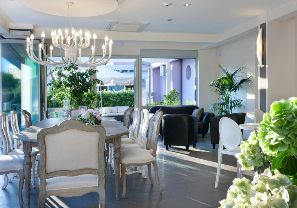 Mūsdienīga un eleganta ēdamistaba ar plašu galdu un stilīgu lustru, kas apvieno dabisko apgaismojumu un zaļos augus. Telpā ir ērti krēsli un izsmalcināts interjers.