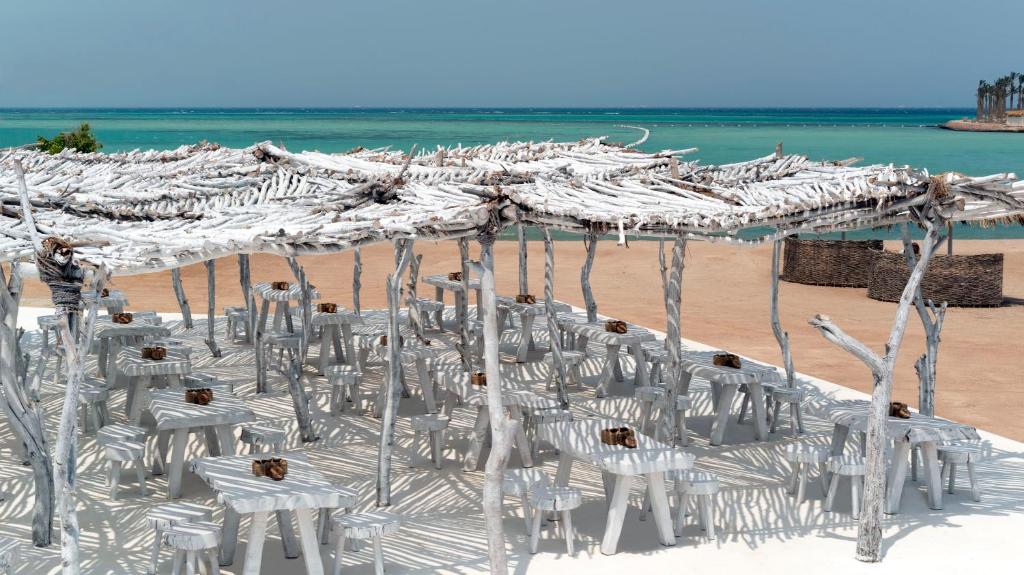 Meraki Resort atklātais restorāns piekrastē ar baltiem galdiem.