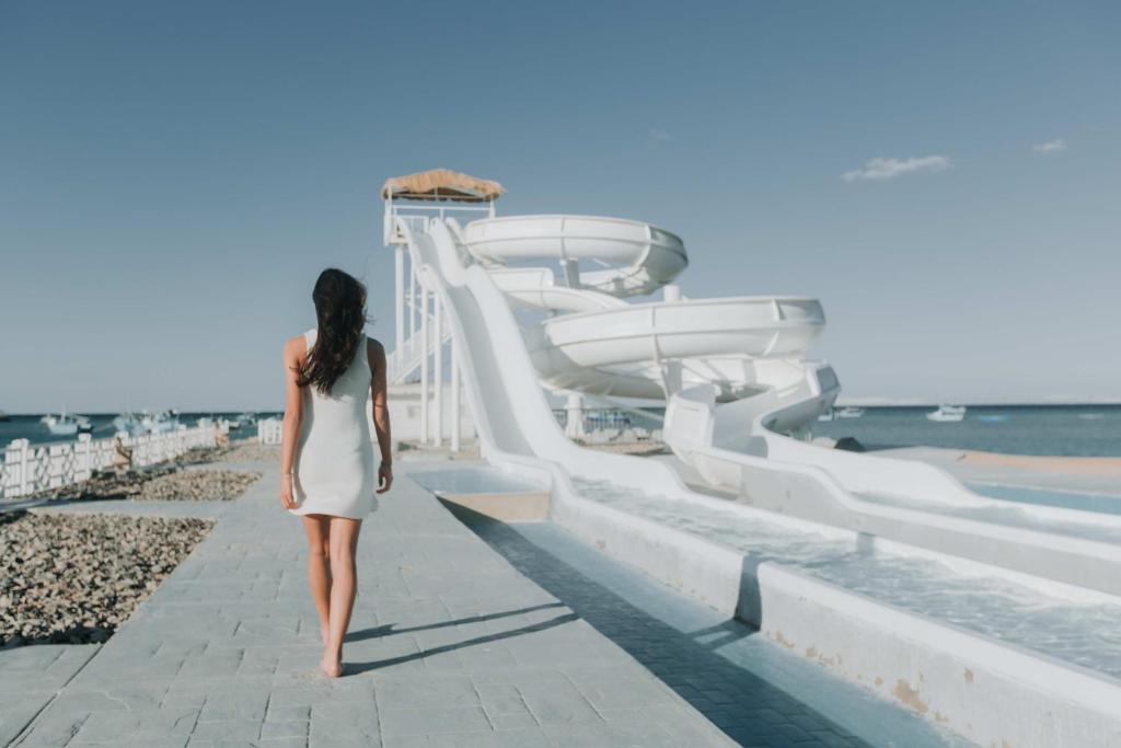 Sieviete pastaigājas pie Meraki Resort ūdens slidām piekrastē