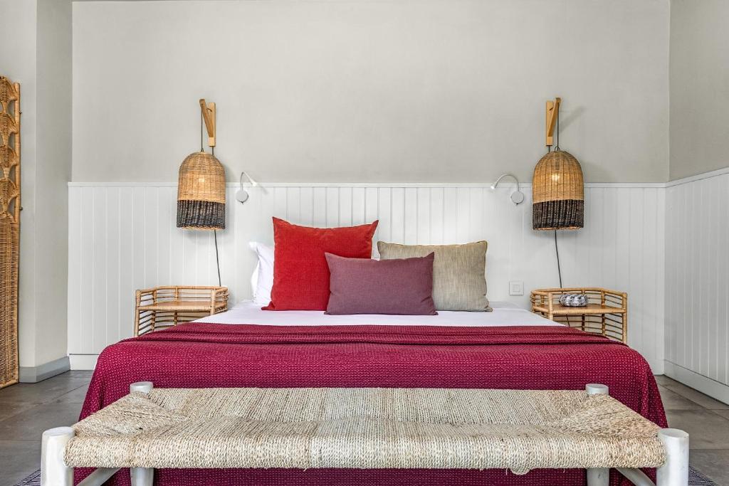 Mūsdienīgs guļamistabas interjers ar ērtu gultu, spilveniem un rattan elementiem, kas rada siltu un viesmīlīgu atmosfēru. Apgaismojums no bambusa lampām piešķir telpai īpašu šarmu.