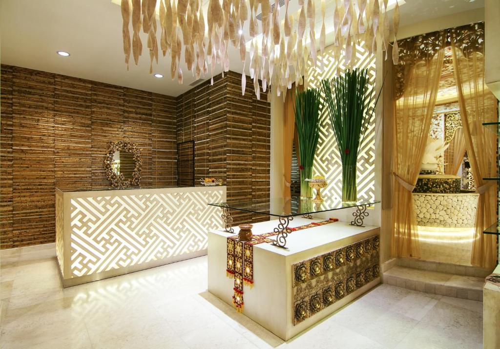 Mūsdienīga un eleganta spa recepcija ar dekoratīviem elementiem, ieskaitot stilīgu apgaismojumu un zaļām augiem. Interjers izceļas ar siltām krāsām un unikālām tekstūrām.